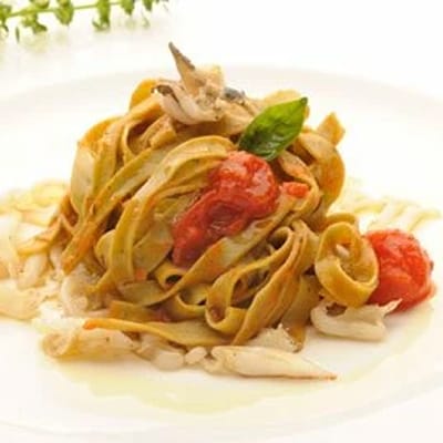 Tagliatelle mit Kirschtomaten-Basilikum-Sauce und Baby-Tintenfischen